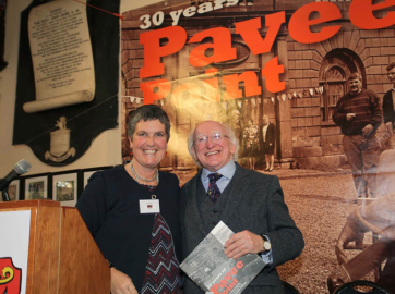 Ronnie Fay Co-Director Pavee Point presents the President with the book '30 Years of Pavee Point'
